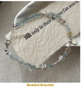 Detail of S925 silver beaded bracelet with light blue faceted beads and star charms