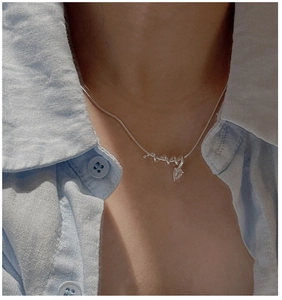Detail of S925 silver snake chain necklace featuring a teardrop zircon pendant on model