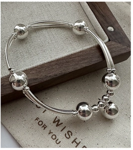 Dettaglio del bracciale in argento sterling S925 con tubi curvi e ciondoli a sfera