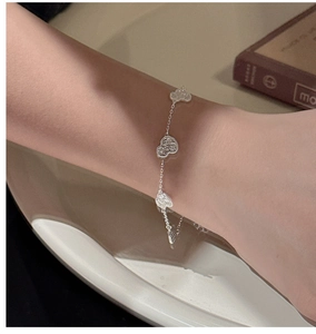 Close-up of S925 sterling silver bracelet featuring hollow heart charms on a female wrist