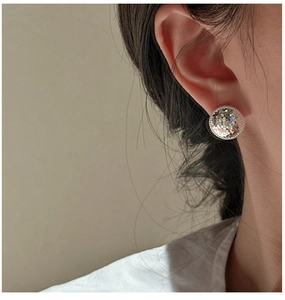 Close-up of S925 sterling silver stud earrings with a textured crushed ice metal finish