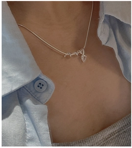 Close-up of S925 sterling silver snake chain with a zircon drop pendant on model
