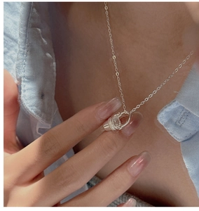 Gros plan du collier avec pendentif seau en argent sterling S925 sur le cou du modèle