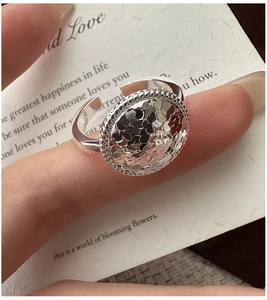 Detail of S925 sterling silver ring featuring a hammered round disc and rope edge