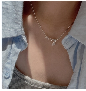 Detail of S925 sterling silver snake chain with water drop zircon pendant on model
