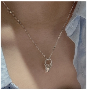 Détail du collier à pendentif seau en argent 925 avec zircone sur la clavicule