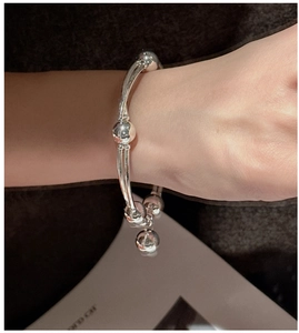 Primo piano del bracciale in argento sterling S925 con perline e tubi curvi al polso