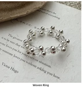 Macro detail of a silver beaded ring with white crystals on artistic paper