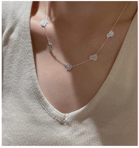 Detail of S925 sterling silver necklace featuring five textured heart pendants on model