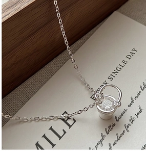 Détail macro du collier seau en argent S925 avec zircon scintillant sur une carte