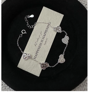 Detailed view of S925 sterling silver bracelet with five textured heart-shaped charms