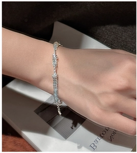 Detail of the light blue beaded silver bracelet on model with elegant background