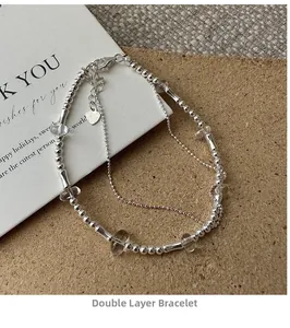 Detail of S925 sterling silver double-layer beaded bracelet with heart charm and lobster clasp