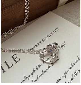 Vue macro du collier avec pendentif seau en argent et zircon clair sur une carte