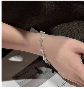 Detail of S925 silver beaded bracelet with light blue gemstones on a model's wrist