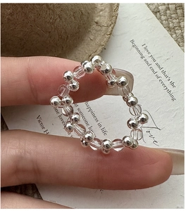 Detailed macro view of S925 sterling silver beads and clear crystal ring on finger