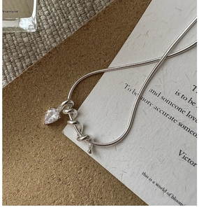 Macro shot of S925 sterling silver snake chain necklace with zircon teardrop pendant