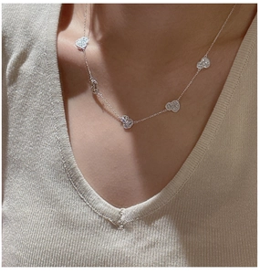 Detail view of a S925 silver heart necklace on model with sparkling pavé center stone