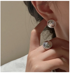 Macro detail of S925 sterling silver crushed ice textured ring and earring set on model