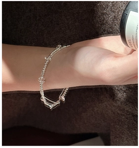 Macro shot of double-layer S925 silver beaded bracelet with clear crystals on wrist