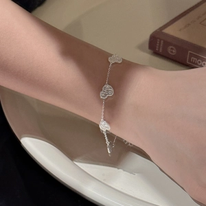 Elegant S925 sterling silver chain bracelet with four textured heart charms on wrist