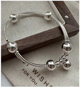 Dettaglio del bracciale in argento S925 con perline e ciondolo a campanellino