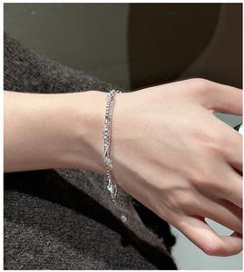 Detail of S925 silver double-layer bracelet with white crystal beads on a model's wrist