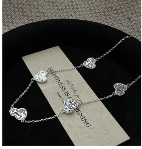 Detailed macro view of S925 sterling silver heart charms on a delicate link chain necklace