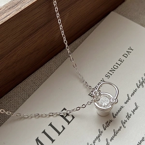 Collier seau en argent sterling S925 avec zircon scintillant sur fond de papier vintage