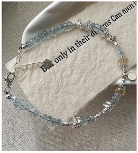 Detail of S925 sterling silver bracelet with aquamarine beads and heart-shaped charm