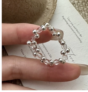 Macro detail of S925 silver beaded ring with clear crystals on a vintage textured background