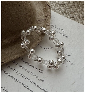Detail of S925 sterling silver beaded ring with clear crystals on retro paper background