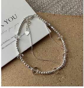 Macro view of a double-layered S925 silver beaded bracelet with clear quartz crystals