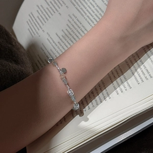 S925 sterling silver aquamarine bracelet worn by model over a vintage book page