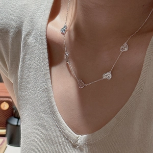 Elegant S925 sterling silver necklace with delicate hollow heart pendants on a female model