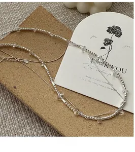 Detail of S925 sterling silver double layer necklace with beads and clear crystal pendant