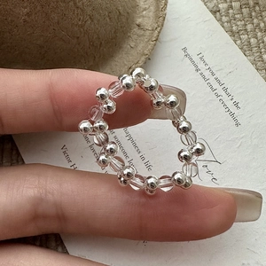 Minimalist S925 silver beaded ring with white crystals shown on finger in a soft lighting