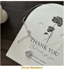 Detailed close-up of S925 sterling silver zircon pendant on a gift card over wood background