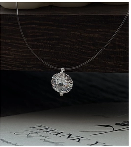 Macro shot of minimalist mermaid tear necklace with floating zircon and invisible fish line