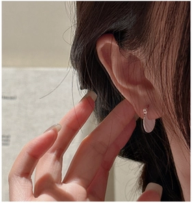 Macro shot of S925 sterling silver pleated round earrings with radial texture on model