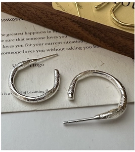 Detailed close-up of S925 sterling silver C-shaped earrings with unique bark texture