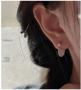 Close-up of S925 sterling silver fan earrings with pleated texture on model