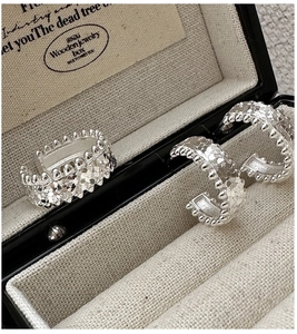 Detailed view of silver S925 C-shaped hoop earrings with sparkling crushed ice texture