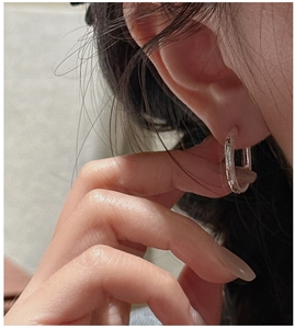 Close-up of classic S925 sterling silver hoop earrings shown on a model's ear