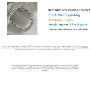 Detailed view of elastic S925 sterling silver beaded bracelet on a white textured tray