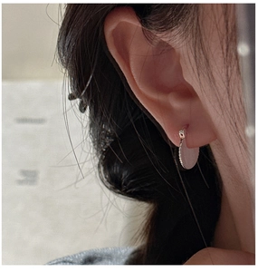 Detailed close-up of S925 sterling silver pleated texture earrings on model ear