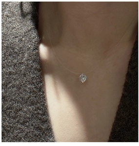 Macro shot of a sparkling zircon pendant hanging on an invisible necklace on neck