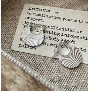 Macro detail of S925 sterling silver hoop earrings with vintage pleated texture and pattern