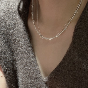 Minimalist S925 silver double-layered necklace with clear beads worn on gray knit top