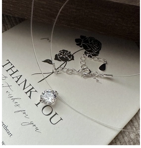 Detail of zircon mermaid tear invisible necklace on a gift card with lobster clasp